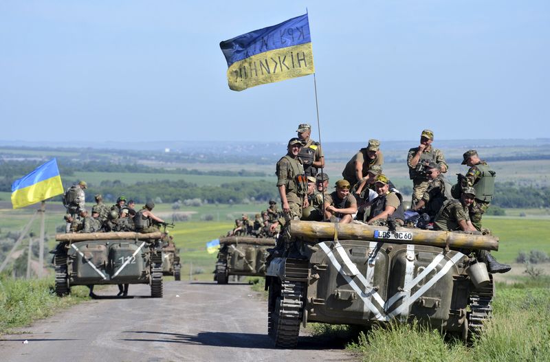 © Reuters. Members of Ukrainian armed forces gather on armoured vehicle on roadside near village of Vidrodzhennya