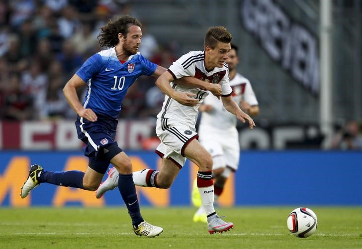 © Reuters. Mix Diskerud, dos EUA, em disputa de bola com Patrick Herrmann (direita), da Alemanha