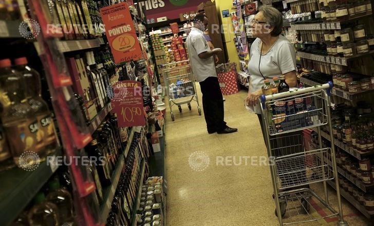 © Reuters. Cliente checa preços em supermercado de São Paulo 