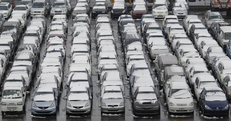 © Reuters. Cars covered with snow are seen at an industrial port before they are loaded to a cargo ship in Yokohama