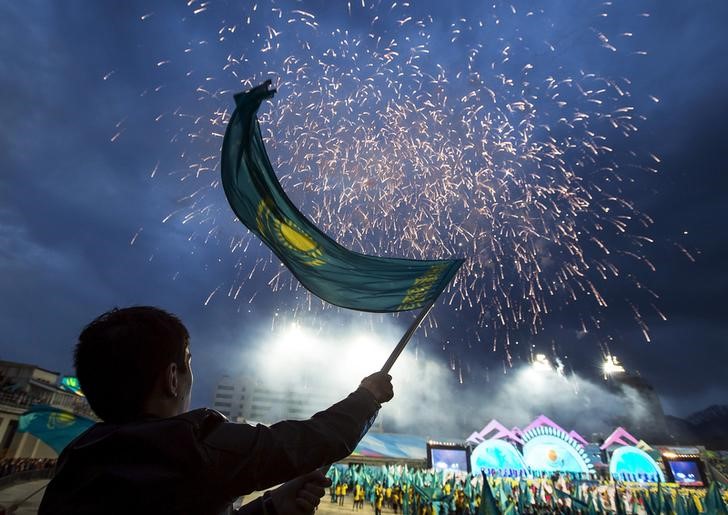 © Reuters. A man waves a national flag during an election campaign rally of Kazakhstan's President Nazarbayev at a stadium in Almaty