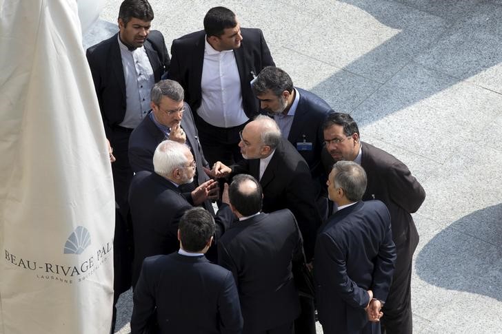 © Reuters. Iran's Foreign Minister Zarif and head of the Atomic Energy Organization of Iran Salehi talk outside with aides after a morning negotiation session with U.S. Secretary of State Kerry in Lausanne