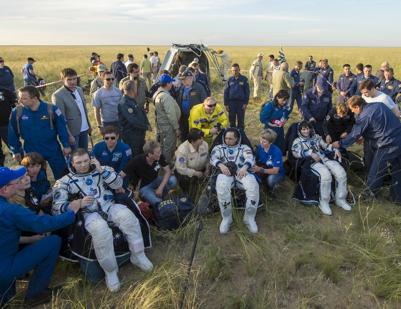 © Reuters. International Space Station crew members rest shortly after landing near town of Zhezkazgan