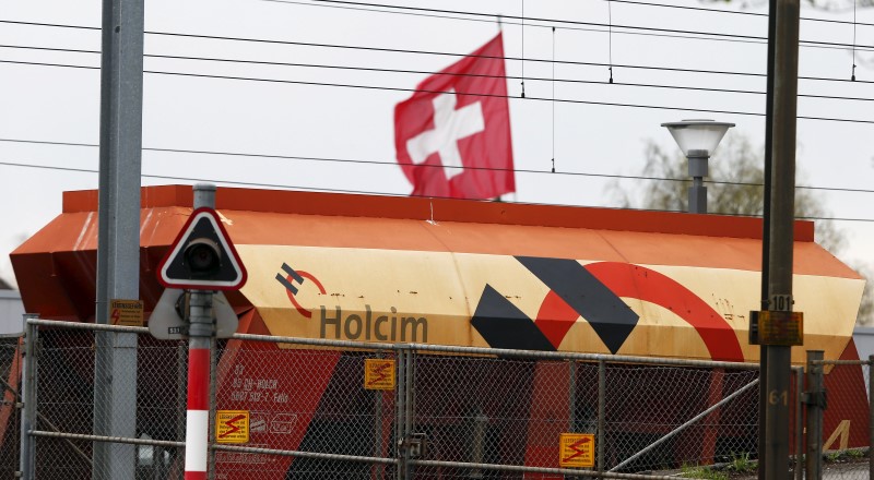 © Reuters. Switzerland's national flag flies behind a railway-car of Swiss cement maker Holcim in Huentwangen