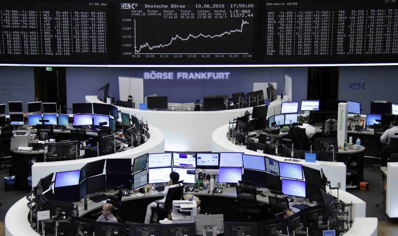 © Reuters. Traders are pictured at their desks in front of the DAX board at the Frankfurt stock exchange