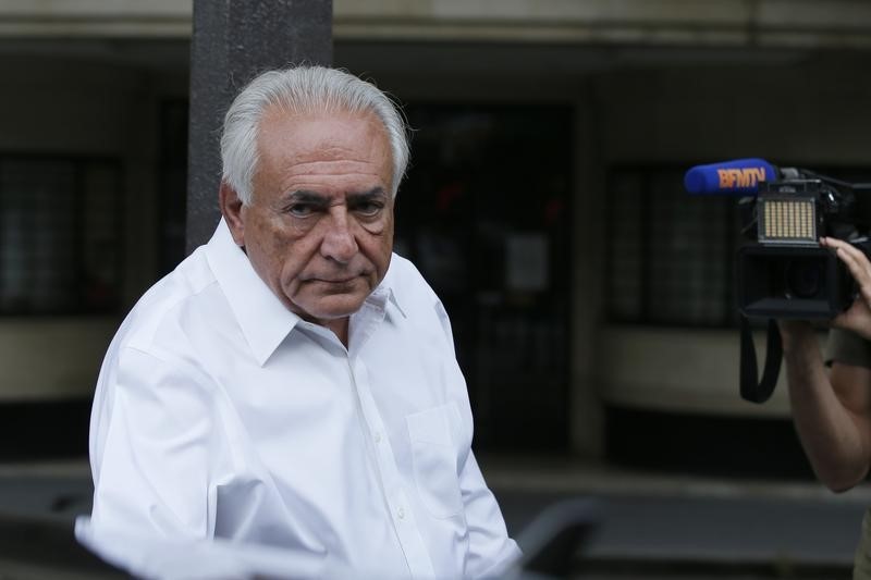 © Reuters. O ex-chefe do FMI, Dominique Strauss-Kahn, entra no carro ao sair do apartamento em Paris