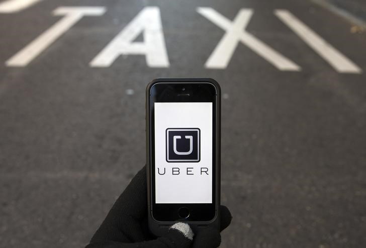 © Reuters. Foto ilustração do logotipo do Uber diante de uma faixa reservada para táxis, em Madri
