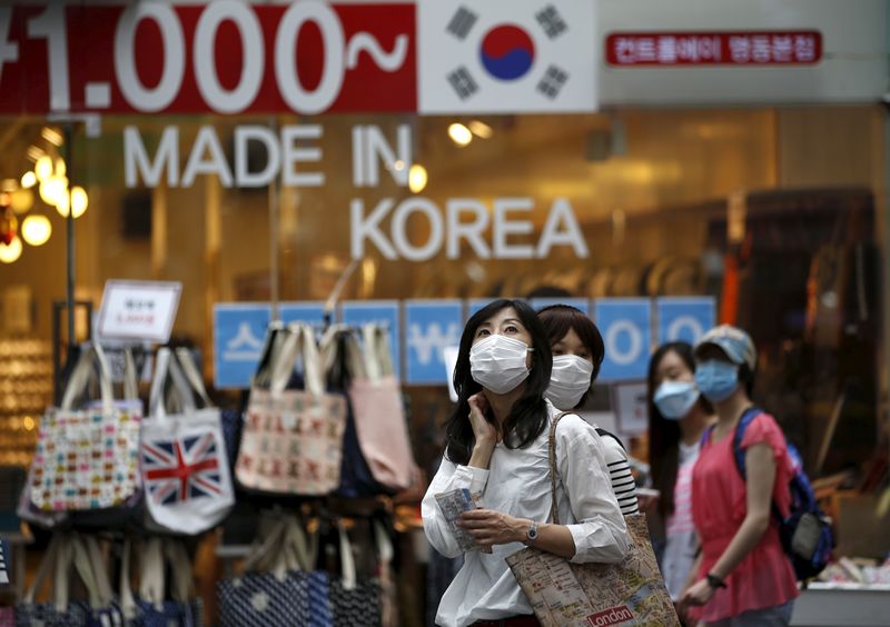 © Reuters. Tourists wearing masks to prevent contracting Middle East Respiratory Syndrome (MERS) look around Myeongdong shopping district in central Seoul