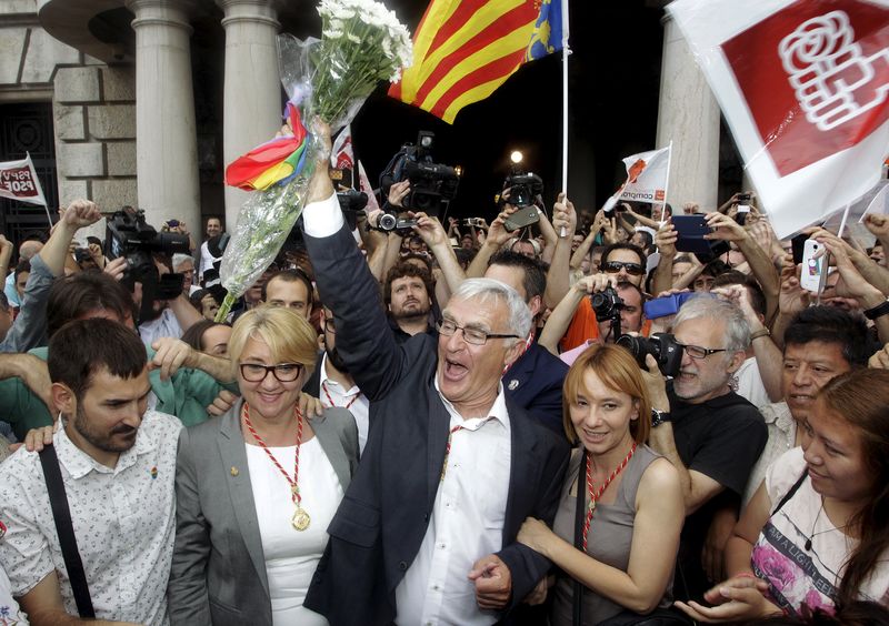 © Reuters. Valencia's new mayor Joan Ribo of Compromis raises a bunch of flowers as he greets people at the townhall square after his swearing-in ceremony, after 24 years of local rule by the People's Party (PP), in Valencia