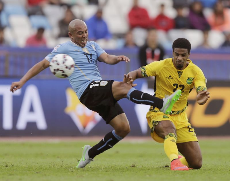 © Reuters. Uruguay's Arevalo Rios fights for the ball with Jamaica's McCleary during their first round Copa America 2015 soccer match at Estadio Regional Calvo y Bascunan in Antofagasta