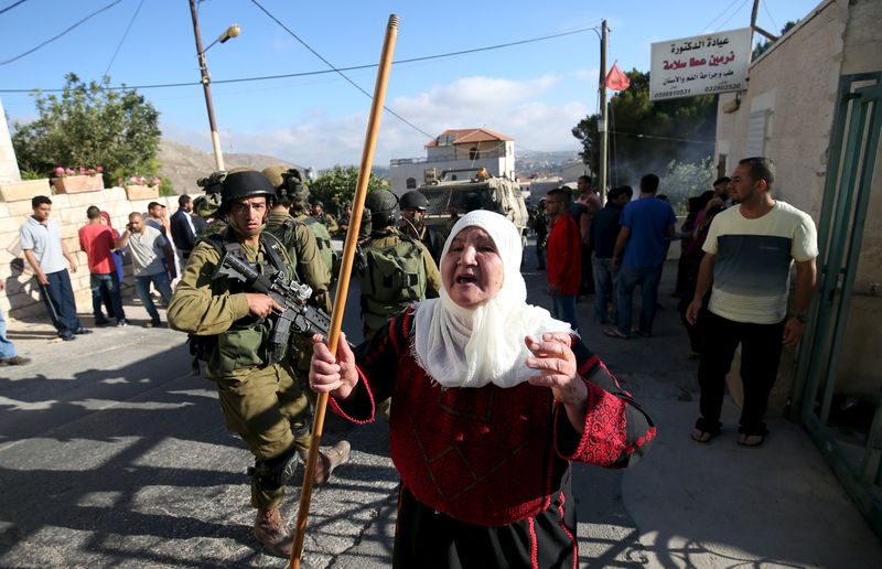 © Reuters. Palestinian woman reacts during confrontations between Palestinians and Israeli troops in Qafr Malik village near the West Bank city of Ramallah