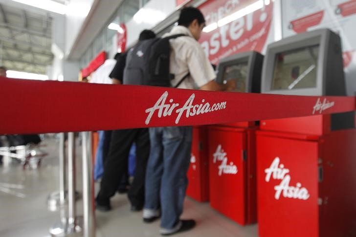 © Reuters. Passengers check in an AirAsia flight at Soekarno-Hatta International Airport in Jakarta