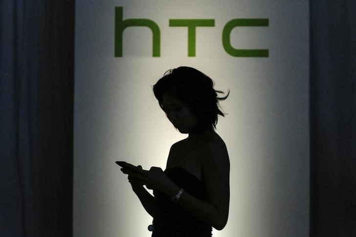 © Reuters. A guest checks her mobile as she arrives for the launch of new HTC products in New York