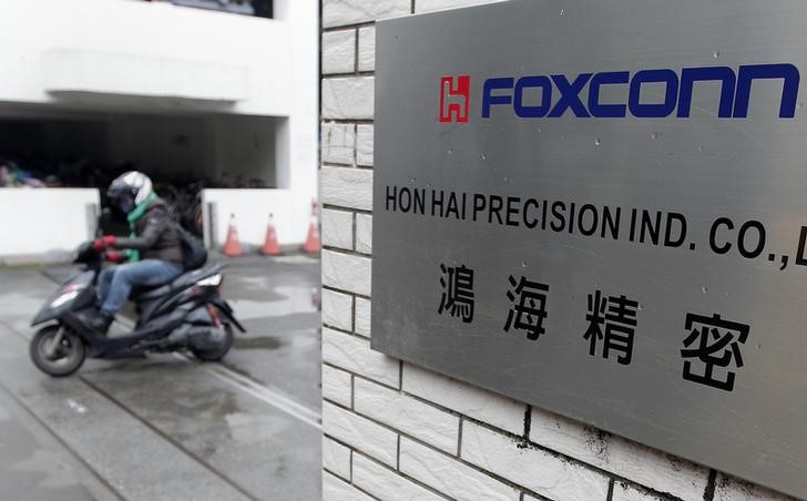 © Reuters. A motorcyclist rides past the entrance of the headquarters of Hon Hai, which is also known by its trading name Foxconn, in Tucheng, New Taipei city
