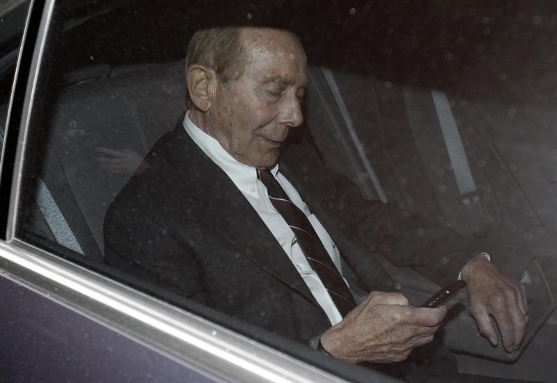 © Reuters. Former CEO of American International Group Inc, Greenberg, checks his phone inside a car after leaving a building in Downtown New York where he was deposed by the Attorney General's office