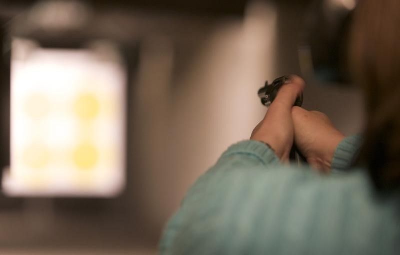 © Reuters. A woman uses her new Colt Single Action Army revolver at Chris' Indoor Shooting Range in Guilford