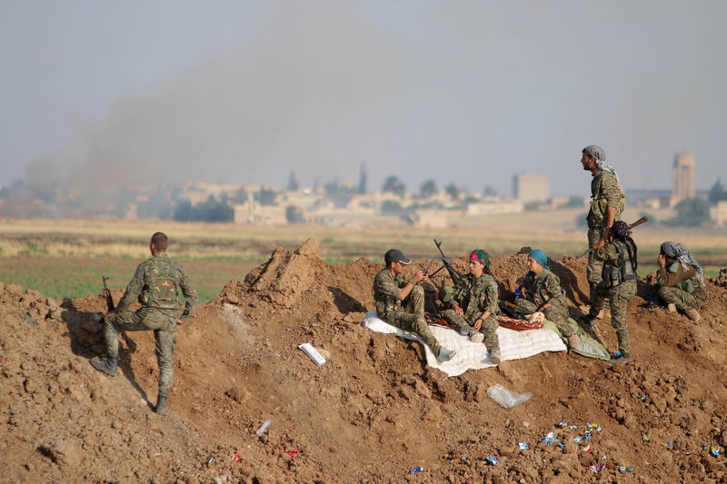 © Reuters. Combatentes do YPG se reúnem em entrada da cidade de Tel Abyad