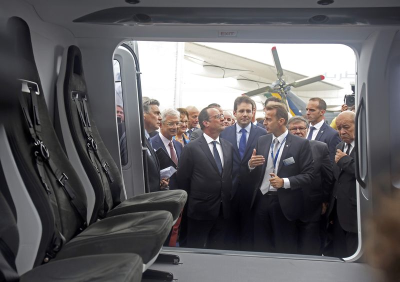 © Reuters. French President Francois Hollande listens to the explanations of Chief Executive Officer of Airbus Helicopters Guillaume Faury during the inauguration of  the 51st Paris Air Show at Le Bourget airport near Paris