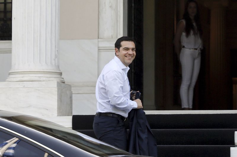 © Reuters. Greek PM Tsipras smiles to journalists as he arrives at his office in Maximos Mansion in Athens