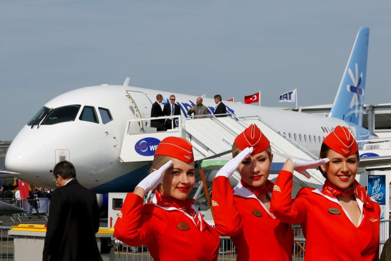 © Reuters. Cabin crew members of Russian carrier Aeroflot pose in front of a Sukhoi Superjet 100 airplane during a photo session at the 51st Paris Air Show at Le Bourget airport near Paris