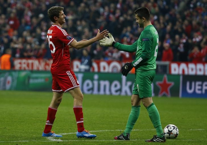 © Reuters. Goleiro do Arsenal Fabianski cumprimentando Mueller, do Bayern de Munique