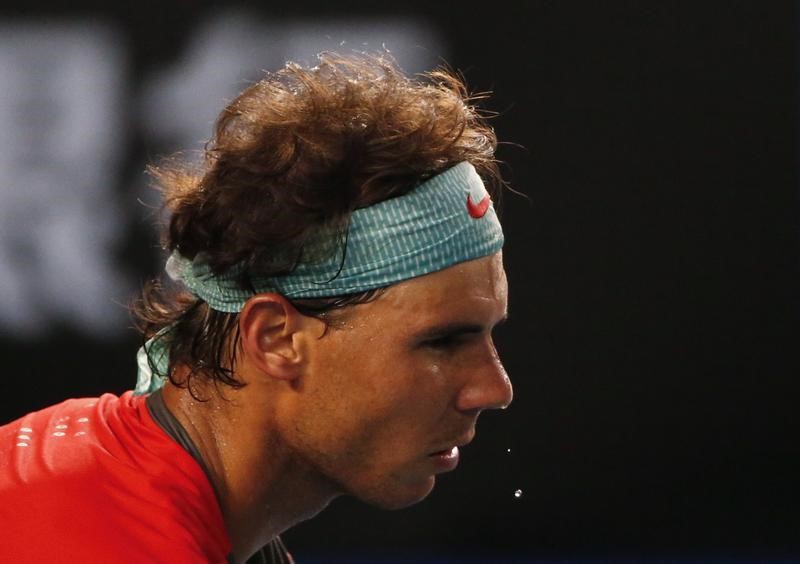 © Reuters. Drops of sweat fall from Nadal of Spain as he serves to Federer of Switzerland during their men's singles semi-final match at the Australian Open 2014 tennis tournament in Melbourne 