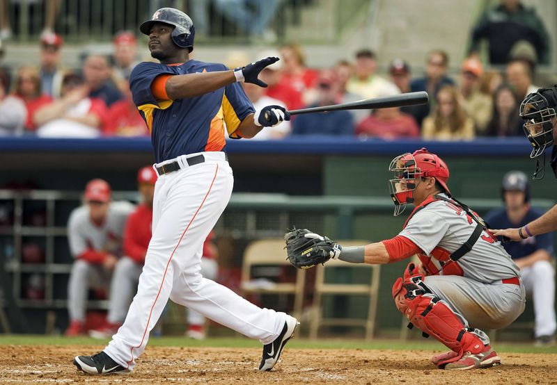 © Reuters. St. Louis Cardinals catcher Johnson looks on as Houston Astros' Carter hits a two-run homer off pitcher Motte during a MLB spring training game in Kissimmee, Florida.