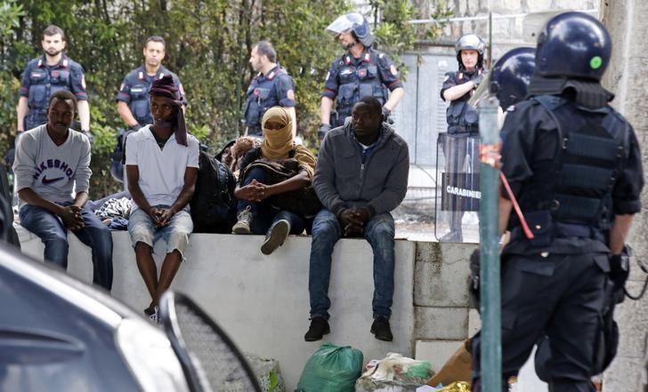 © Reuters. A group of migrants is surrounded by Italian police during their evacuation from the Saint Ludovic border crossing on the Mediterranean Sea between Vintimille and Menton