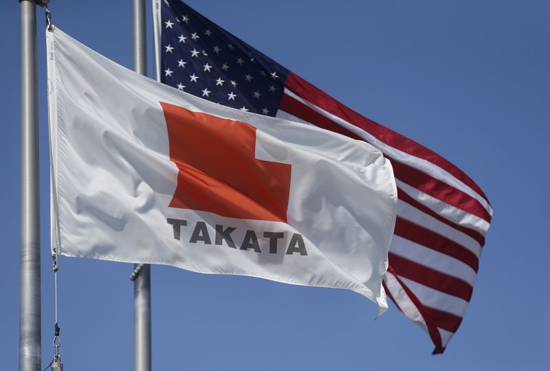 © Reuters. A flag with the Takata logo flies alongside a U.S. flag outside Takata corporation in Auburn Hills, Michigan 