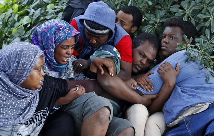 © Reuters. Imigrantes reagem ao serem expulsos de Saint Ludovic pela polícia italiana