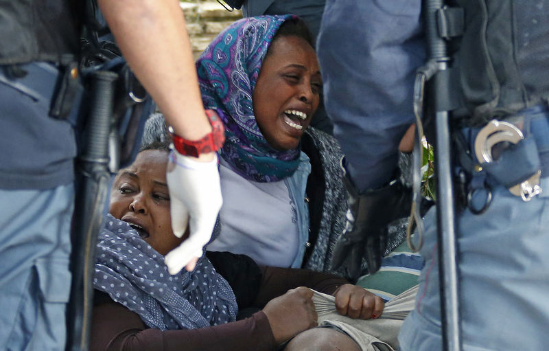 © Reuters. A group of migrants react as they are evacuated by Italian police from the Saint Ludovic border crossing on the Mediterranean Sea between Vintimille and Menton, France