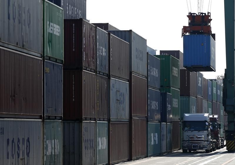 © Reuters. Trucks line up as containers are loaded at a port in Tokyo