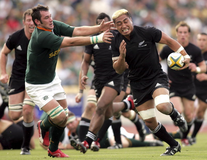 © Reuters. File photo of New Zealand's Jerry Collins avoiding a tackle by South Africa's Pedrie Wannenberg during their Tri-Nations rugby union match in Rustenburg, South Africa