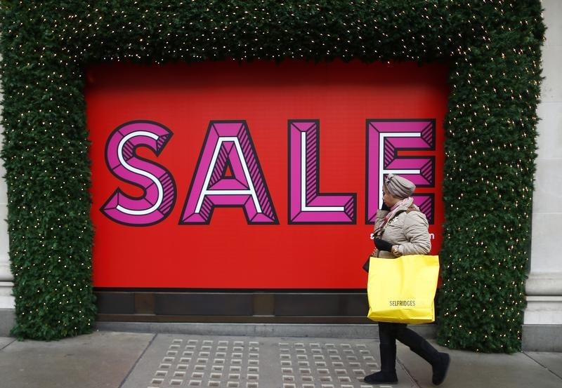 © Reuters. A woman walks past Selfridges department store after shopping on the first day of their sales, in central London