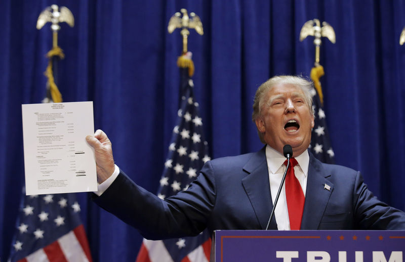 © Reuters. U.S. Republican presidential candidate Trump holds up his financial statement as he formally announces his campaign for the 2016 Republican presidential nomination at Trump Tower in New York