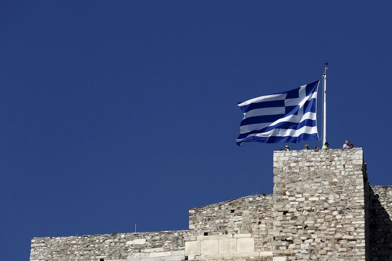 © Reuters. Turistas sob a bandeira da Grécia em Acrópole, Atenas