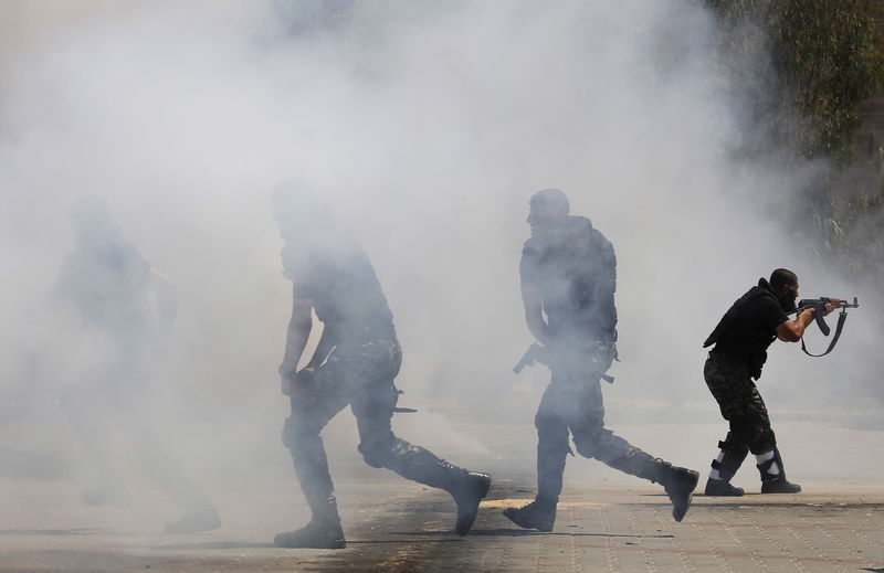 © Reuters. Smoke is seen as members of Palestinian national security forces loyal to Hamas demonstrate their skills at a scene simulating breaking into a site during a military graduation ceremony in the northern Gaza Strip 