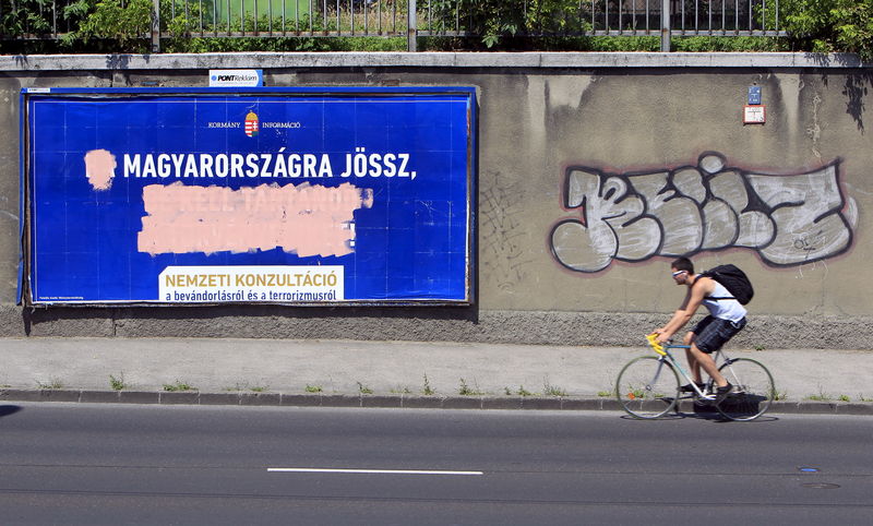 © Reuters. Outdoors do governo difamando imigrantes desfigurado por ativistas da oposição, em Budapeste