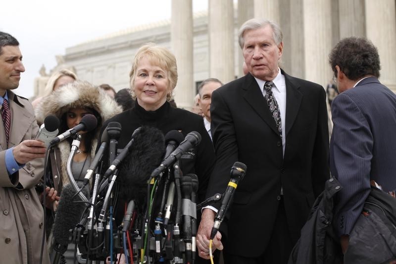 © Reuters. Pamela Hurst and her husband Douglas Hurst, plaintiffs against the U.S. government in the King v. Burwell case,  speak to reporters after arguments at the Supreme Court building in Washington