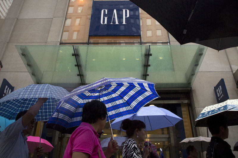 © Reuters. People carrying umbrellas pass by a Gap store on 5th avenue in midtown Manhattan in New York