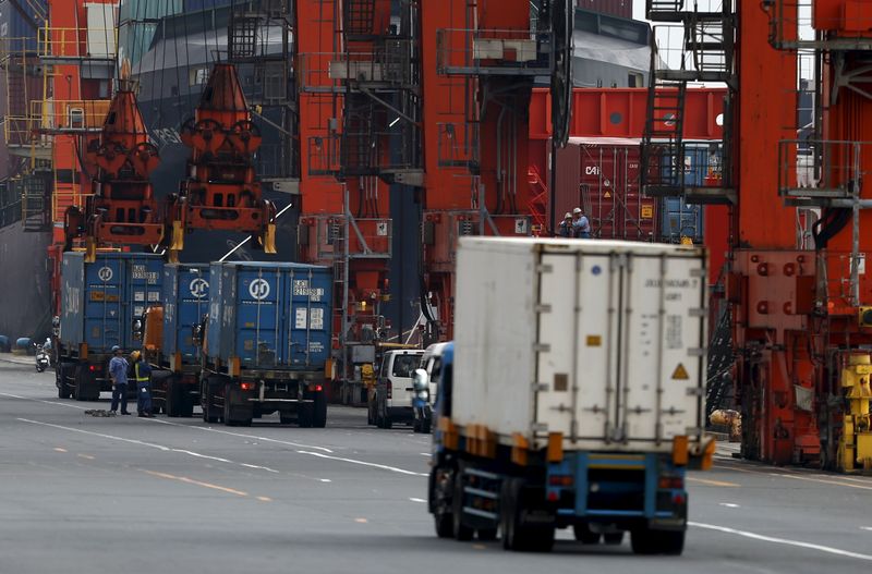 © Reuters. People work near cargo containers loaded from trucks at a port in Tokyo