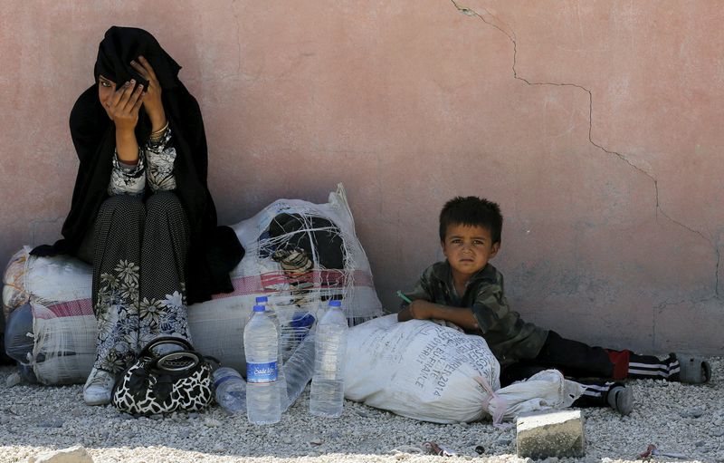 © Reuters. Refugiada síria e seu filho na cidade de Akcakale, na Turquia