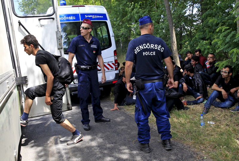 © Reuters. An Iraqi steps onto a police bus as they are detained by Hungarian police after crossing the Hungarian-Serbian border illegally near the village of Asotthalom