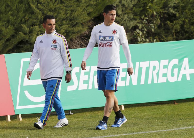 © Reuters. Colombiia's player James Rodriguez walks with an assistant during a training session in Santiago