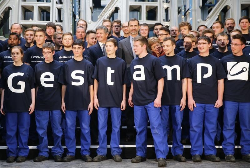 © Reuters. Spain's King Felipe and Riberas, President and CEO of Gestamp pose for a family picture with Gestamp workers at Gestamp chassis innovation center in the western German city of Bielefeld