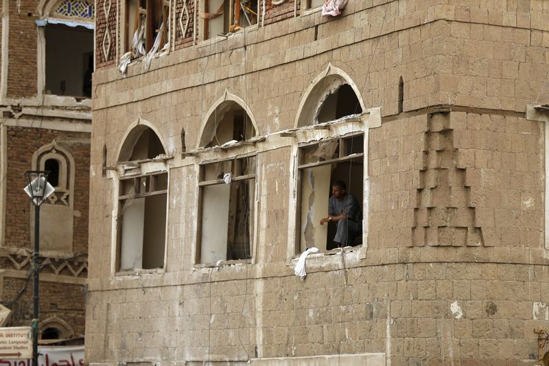 © Reuters. A man looks out from his damaged house at the site of a car bomb attack outside the Qubbat al-Mahdi mosque in Yemen's capital Sanaa