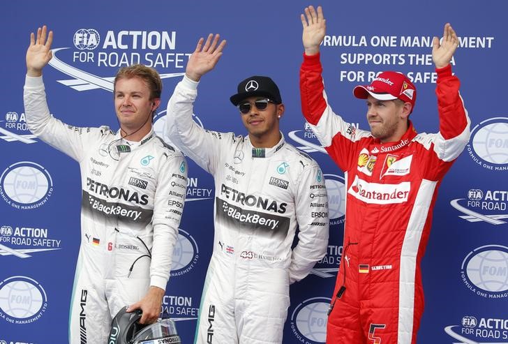 © Reuters. Mercedes Formula One driver Hamilton of Britain is flanked by Ferrari's Vettel of Germany and team mate Rosberg of Germany following the qualifying session for the Austrian F1 Grand Prix in Spielberg