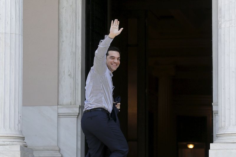 © Reuters. El primer ministro de Grecia,  Alexis Tsipras, saluda a sus partidatios tras arribar a su despacho en la Mansión Maximos en Atenas
