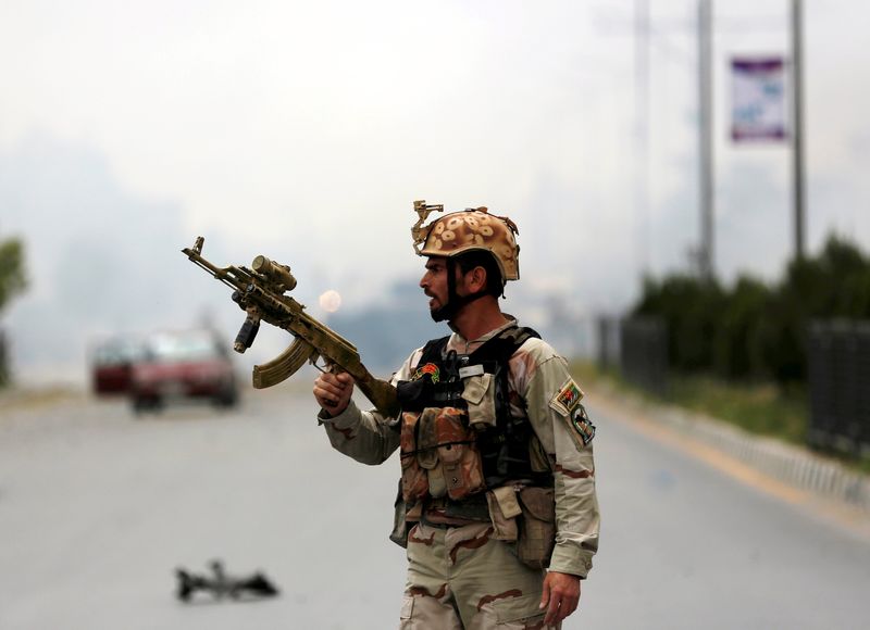 © Reuters. Member of Afghan security forces holds a rifle at the site of an attack near the Afghan parliament in Kabul, Afghanistan