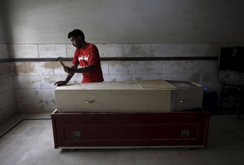 © Reuters. Voluntário preparando caixão para morto devido a onda de calor no Paquistão